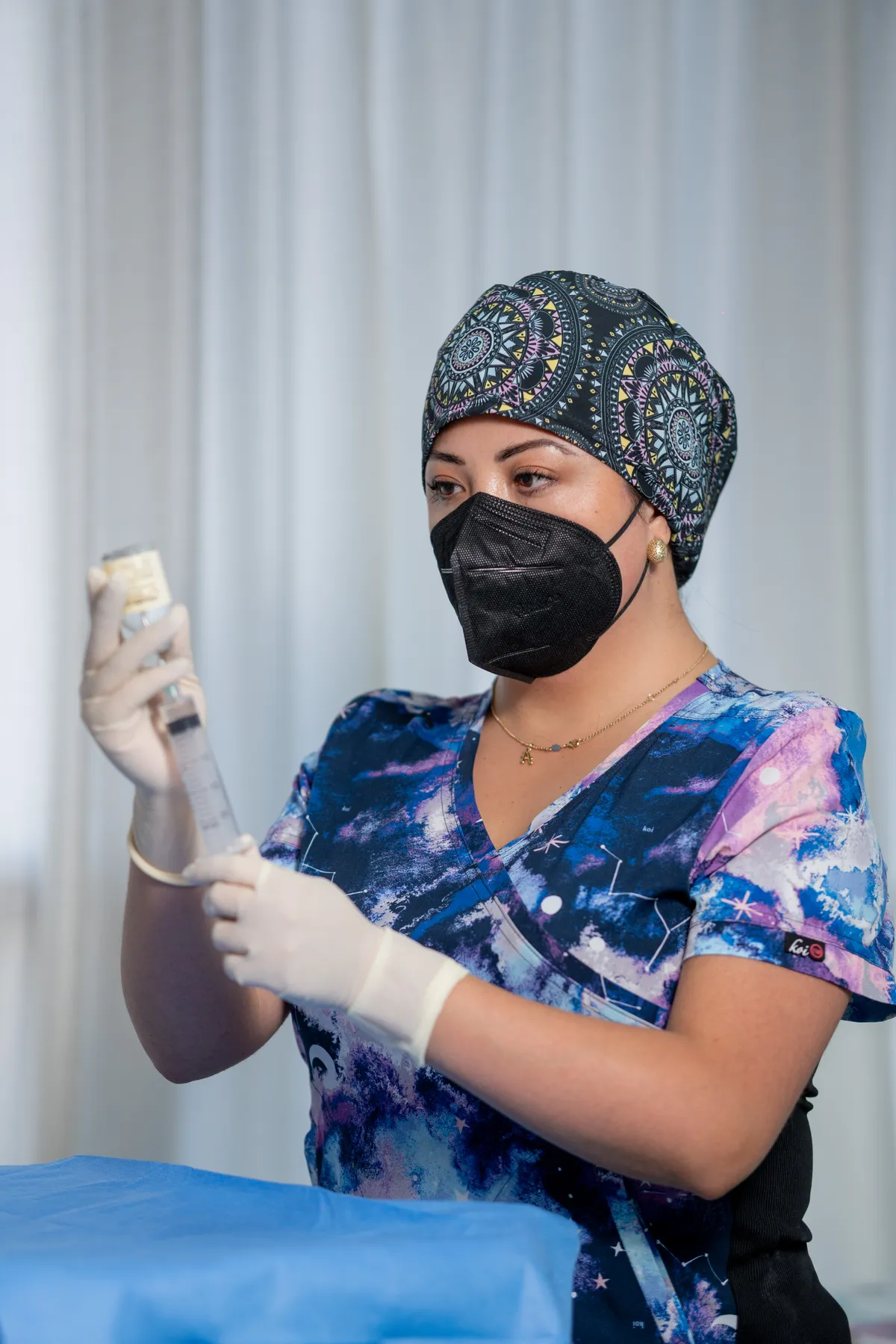 Dra. Alytsa Garcia preparando una infiltración con guantes y mascarilla